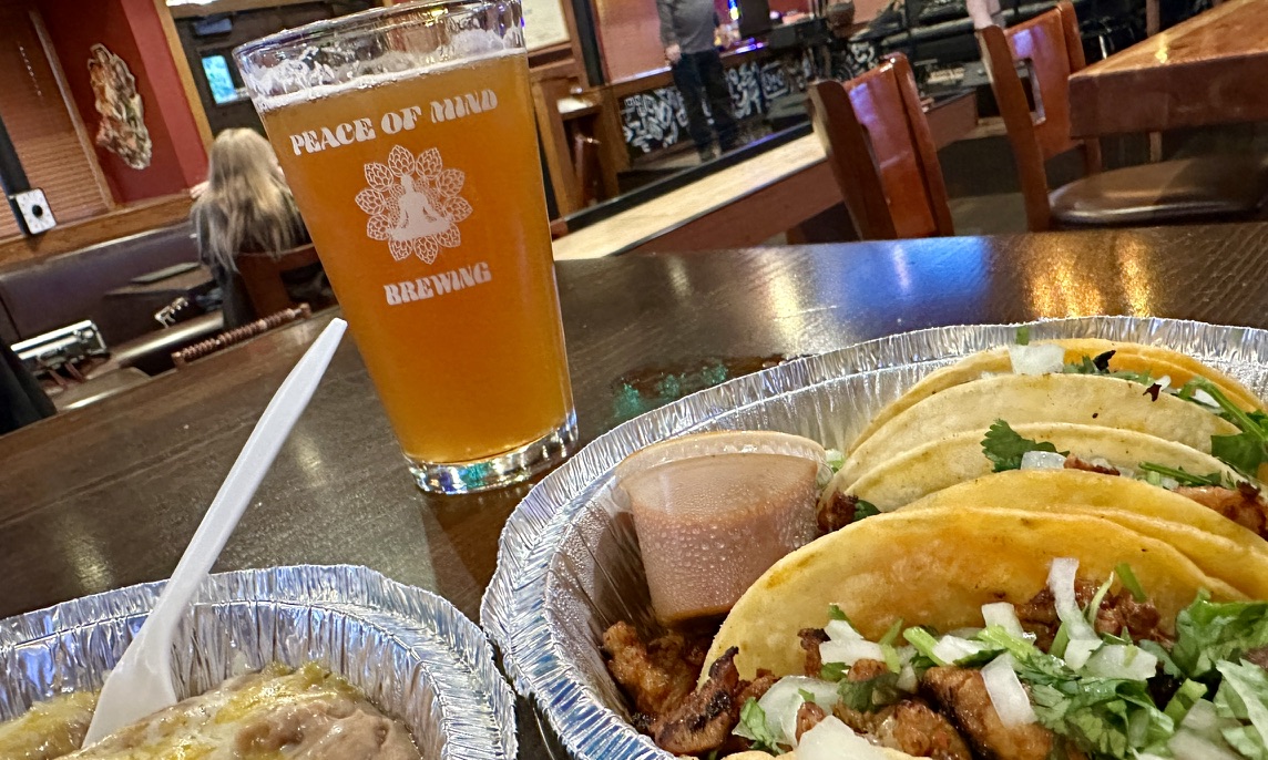 A pint from Peace of Mind Brewing alongside a tray of tacos