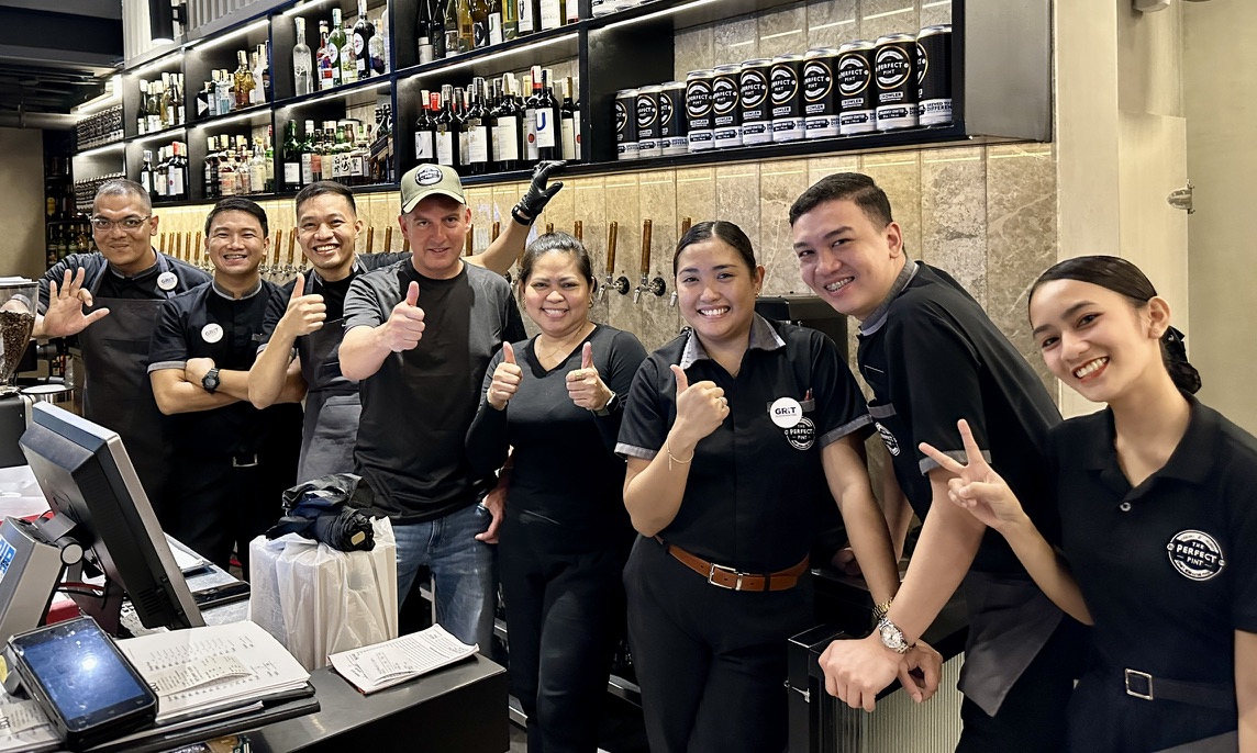 Rob with the smiling team behind the bar at The Perfect Pint in Manila