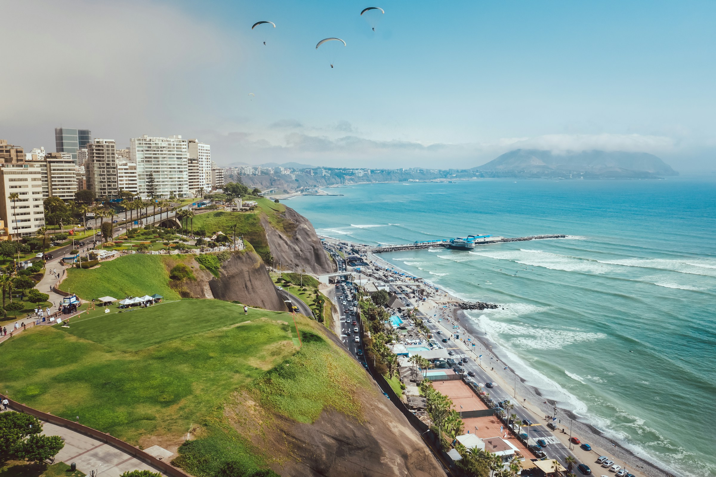 Lima’s green coastal cliffs above the blue Pacific Ocean